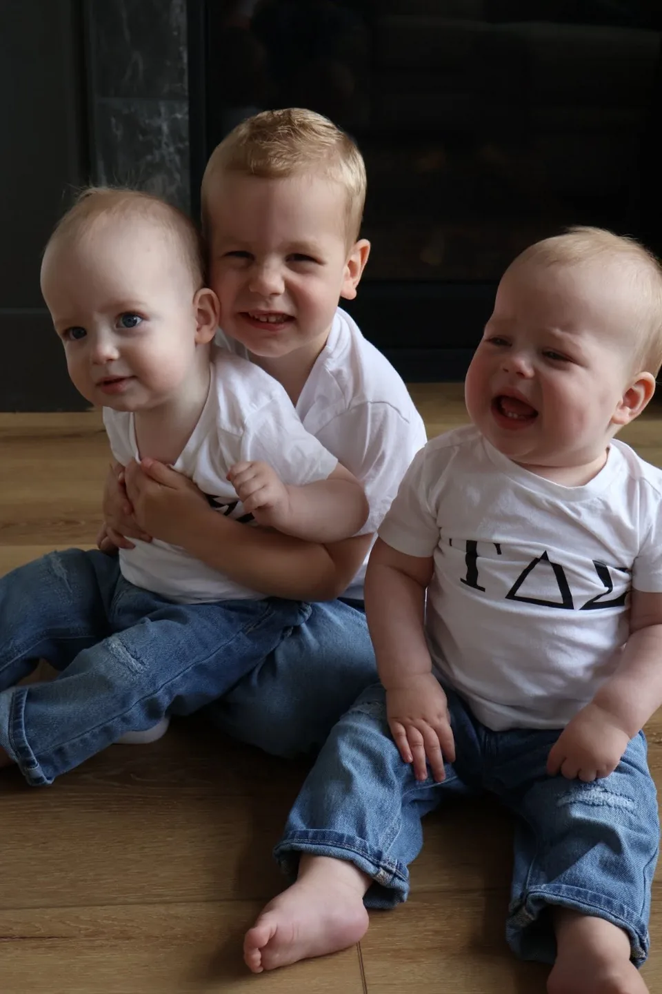 Leland sitting between his younger twin brothers Sutton and Tatum